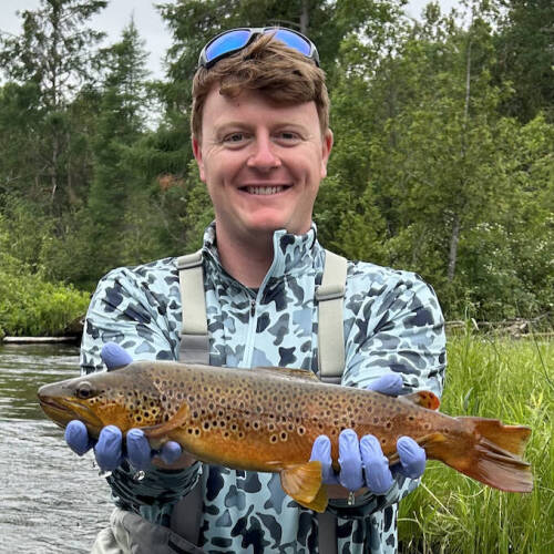 Logan Clark displays a brown trout.